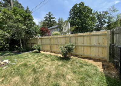 Wooden privacy fence and chain-link fence in a suburban backyard