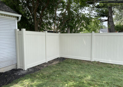 Vinyl privacy fence with posts and panel sections in a residential setting